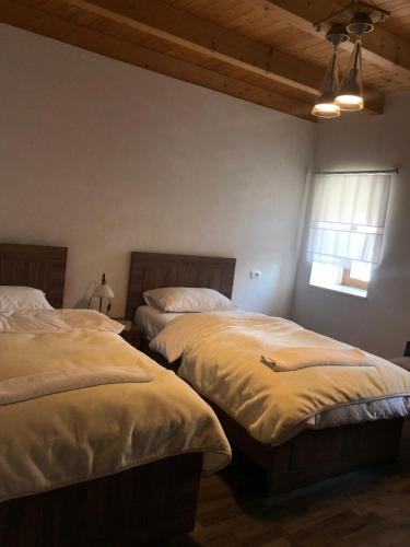 a bedroom with two beds and a window at Bujtina Gjana in Kukës