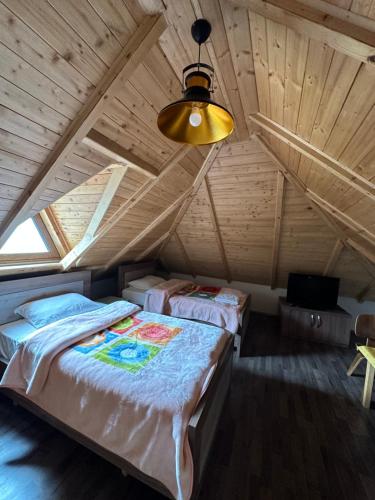 a bedroom with two beds in a attic at Bujtina Gjana in Kukës