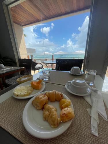 two plates of pastries on a table with a view at Pousada Ceu e Mar in Pipa