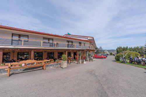 a building with people sitting on benches in front of it at Hotel Racek in Úštěk