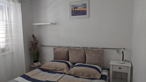 um quarto com uma cama e um candeeiro sobre uma mesa em Apartma Ela em Koper