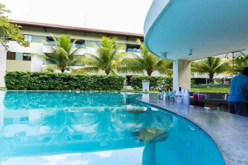 uma piscina com água azul num resort em Flat Beira Mar - Carneiros Beach Resort em Tamandaré