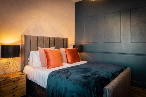 a bedroom with a large bed with orange pillows at Luxurious Apartment in Prestatyn in Prestatyn