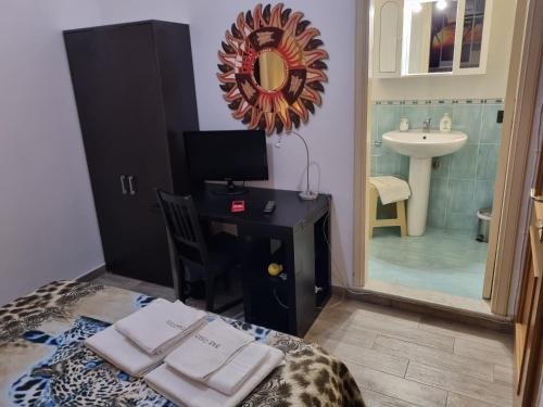 um quarto com uma secretária, um lavatório e um espelho em B&B Castelluccio em Villafranca Tirrena