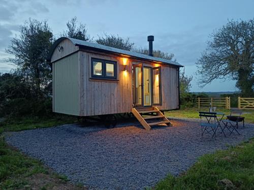 a tiny house with a porch and a table and chairs at Old Quay Escape in Tenby