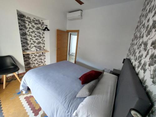 a bedroom with a white bed with a red pillow at apartamentos fuente nueva sande in Cáceres