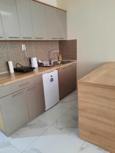 eine Küche mit weißen Schränken und einem weißen Kühlschrank in der Unterkunft Apartment Tine in Ohrid