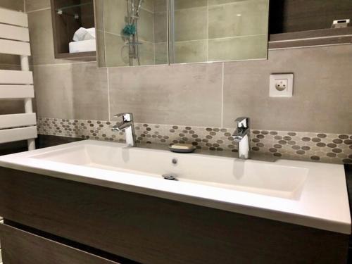 une salle de bain avec un lavabo blanc et un miroir dans l'établissement LA PAIX, à Aix-en-Provence