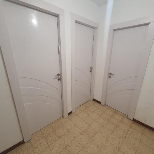 two white doors in a room with a tile floor at צפת שלי in Safed