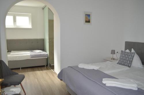 a bedroom with a bed and a chair and a mirror at Jägerhotel in Annenheim