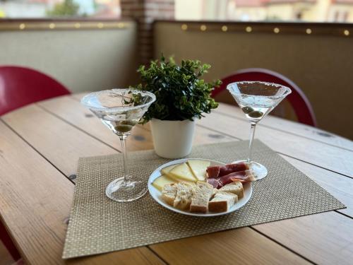 a table with two wine glasses and a plate of food at Casa Rural La Chistera in Avila
