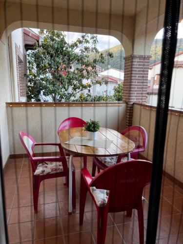 a table and chairs on a balcony with a window at Casa Rural La Chistera in Avila
