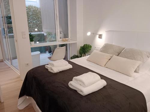 エルチェにあるLujoso y acogedor apartamento "súper céntrico" en ELcheのベッドルーム1室(ベッド1台、タオル2枚付)