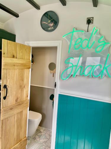 a bathroom with a toilet and a sign on the wall at The Orchard Retreat in Shrewsbury