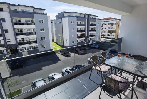 錫比烏的住宿－Select Apartment SIBIU，阳台配有桌椅和建筑