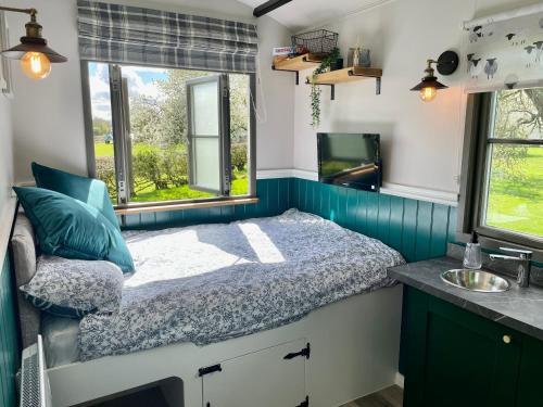 Dormitorio pequeño con cama y lavamanos en The Orchard Retreat en Shrewsbury