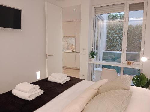 Un dormitorio con una cama blanca con toallas. en Lujoso y acogedor apartamento "súper céntrico" en ELche, en Elche