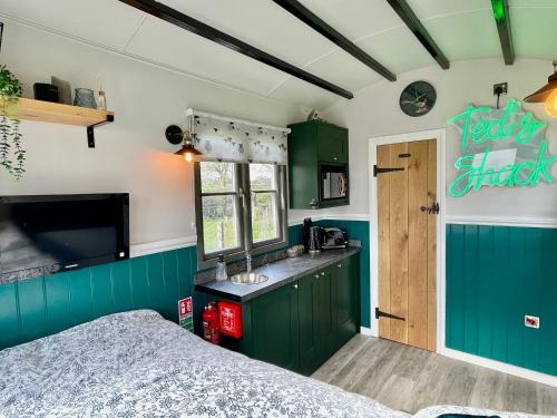 a kitchen with green cabinets and a bed in a room at The Orchard Retreat in Shrewsbury