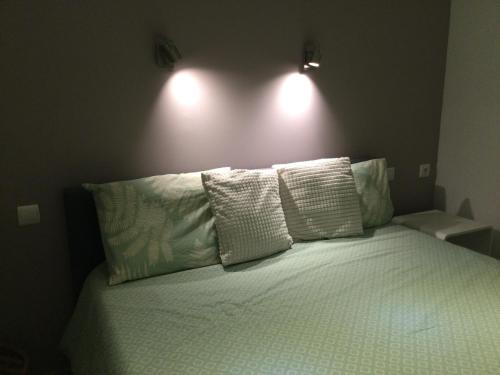 1 cama con 3 almohadas en un dormitorio en Escapade Vallée du Doux, en Tournon-sur-Rhône