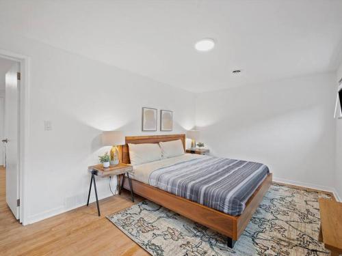 a bedroom with a bed and a table in a room at Stylish and Modern 2Bdr Apartment in Millvale/Lawrenceville in Pittsburgh
