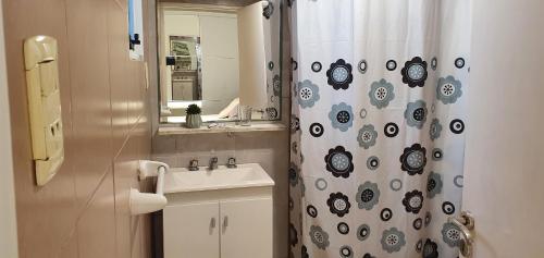 a bathroom with a sink and a shower curtain at Departamentos Temporales Moreno in Reconquista
