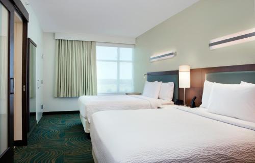 a hotel room with two beds and a window at SpringHill Suites by Marriott Orlando at FLAMINGO CROSSINGS Town Center-Western Entrance in Orlando