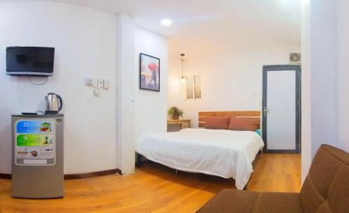 a bedroom with a bed and a tv and a couch at Language Exchange Hotel 3 in Ho Chi Minh City