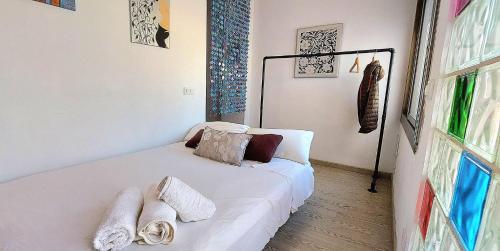 um quarto com uma cama branca e toalhas em APARTAMENTO ISAMAR em Calella