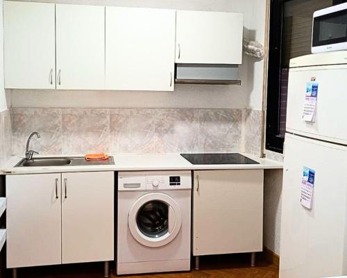een keuken met een wasmachine en een wastafel bij Hostel Pepe Viajes in Madrid