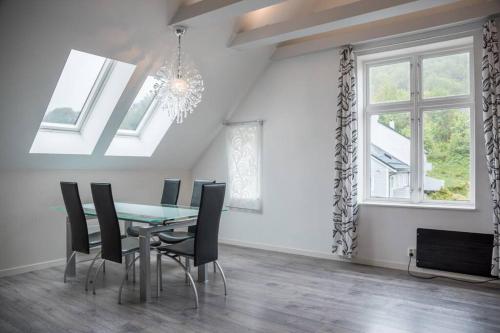 a dining room with a table and chairs and windows at Modern apartment 7 min to center in Bergen