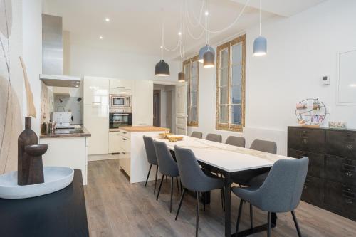 une cuisine et une salle à manger avec une table et des chaises dans l'établissement Appartement Haussmannien à Sète, à Sète