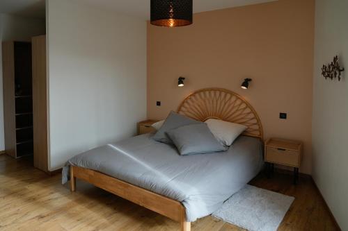 a bed with a wooden headboard in a room at Auberge du Vieux Pont in Brignais