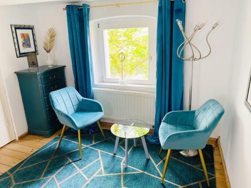 two blue chairs and a table in a room at Historisches Fachwerkhaus in Königsberg in Bayern