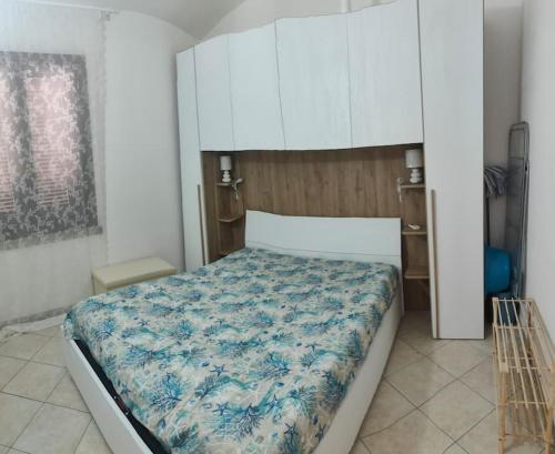 une chambre avec un grand lit avec une couverture bleue dans l'établissement Isola Rossa La Paduledda Appartamento vista mare Il Mirto, à Cascabraga