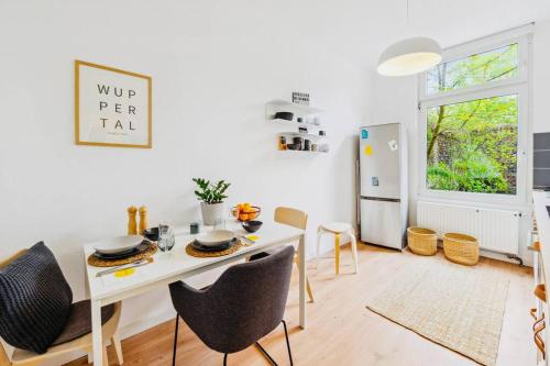 - une salle à manger blanche avec une table et des chaises blanches dans l'établissement Wuppertaler Altbau-Traum Gutenberg, à Wuppertal