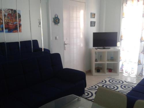 a living room with a couch and a tv at Rudi Studios in Sarti