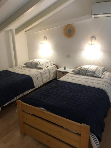 - 2 lits dans une chambre avec 2 lampes murales dans l'établissement Altura, à Zonza