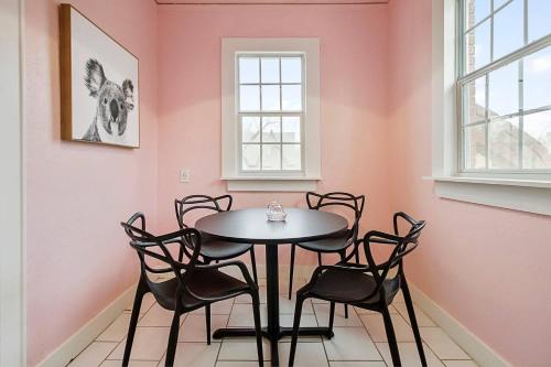 a table and chairs in a room with pink walls at Pastel Palace - near Plaza & Uptown 23rd in Oklahoma City