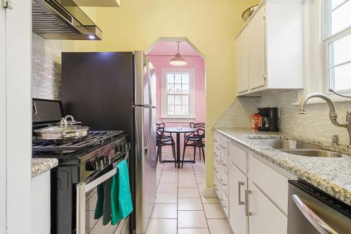 a kitchen with a black refrigerator and a table at Pastel Palace - near Plaza & Uptown 23rd in Oklahoma City