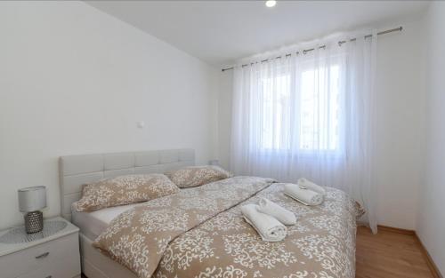 a bedroom with a bed with two white towels on it at Apartman Roko in Ploče