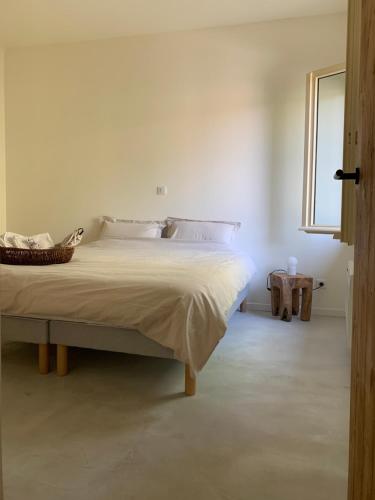 une chambre blanche avec un grand lit avec une fenêtre dans l'établissement Louise, à Boulbon