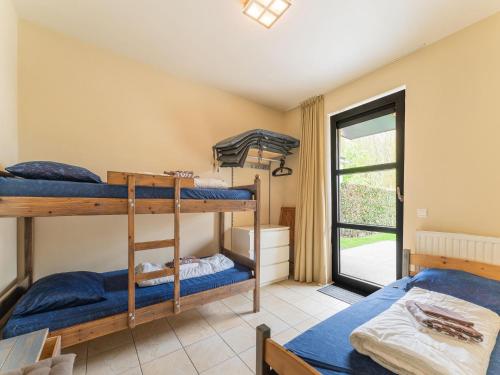 a room with three bunk beds and a window at Apartment, located a stone's throw away from the sea in Cadzand-Bad