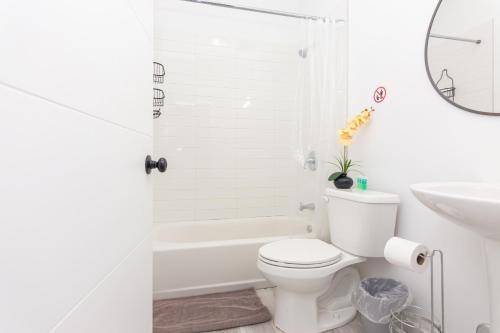 Baño blanco con aseo y lavamanos en Home Midtown Miami - Wynwood area with backyard - Art District near to Beach, en Miami