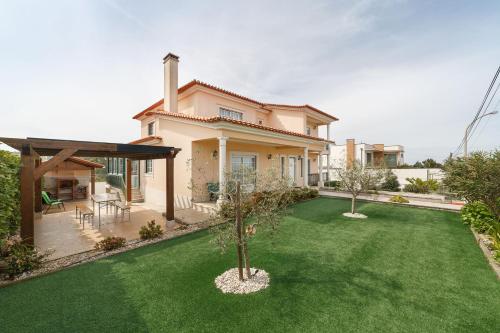 a house with a yard with a green lawn at Casa do Monte Amarelo in Fátima