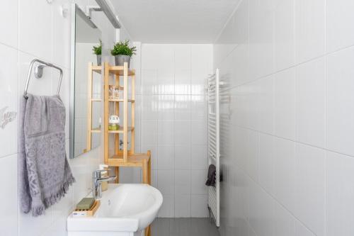 Baño blanco con lavabo y aseo en New Olivka House en Anavissos