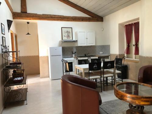 a kitchen and living room with a table and chairs at Le Moulin de Milan in Cheval-Blanc