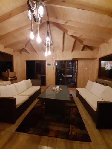a living room with white couches and a table at Los queñes Country House in Los Queñes