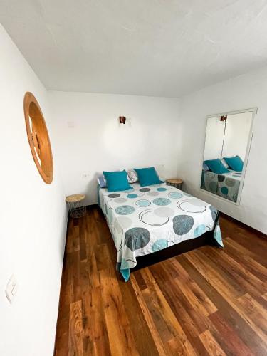 a bedroom with a bed with blue pillows at CASA DOMINGO 1 in La Santa