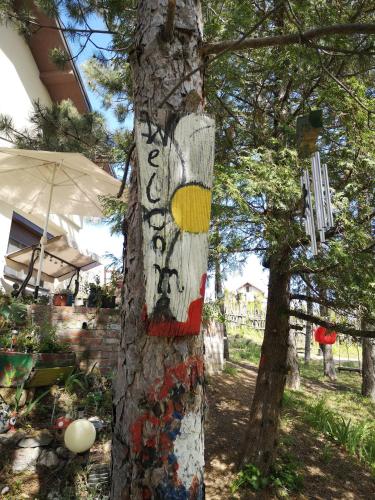 a tree with a sign painted on the side of it at Apartman Snežana Jugovo in Smederevo