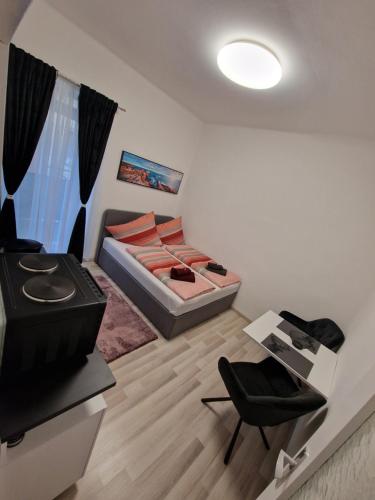 - une petite chambre avec un lit et une chaise dans l'établissement Appartement 223, à Bad Aussee